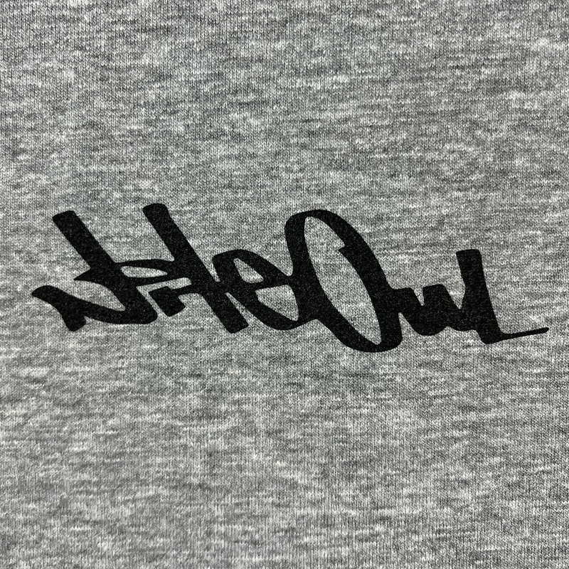 Front close-up of Oakland artist Nite Owl logo/signature in black ink on the chest of a grey t-shirt.