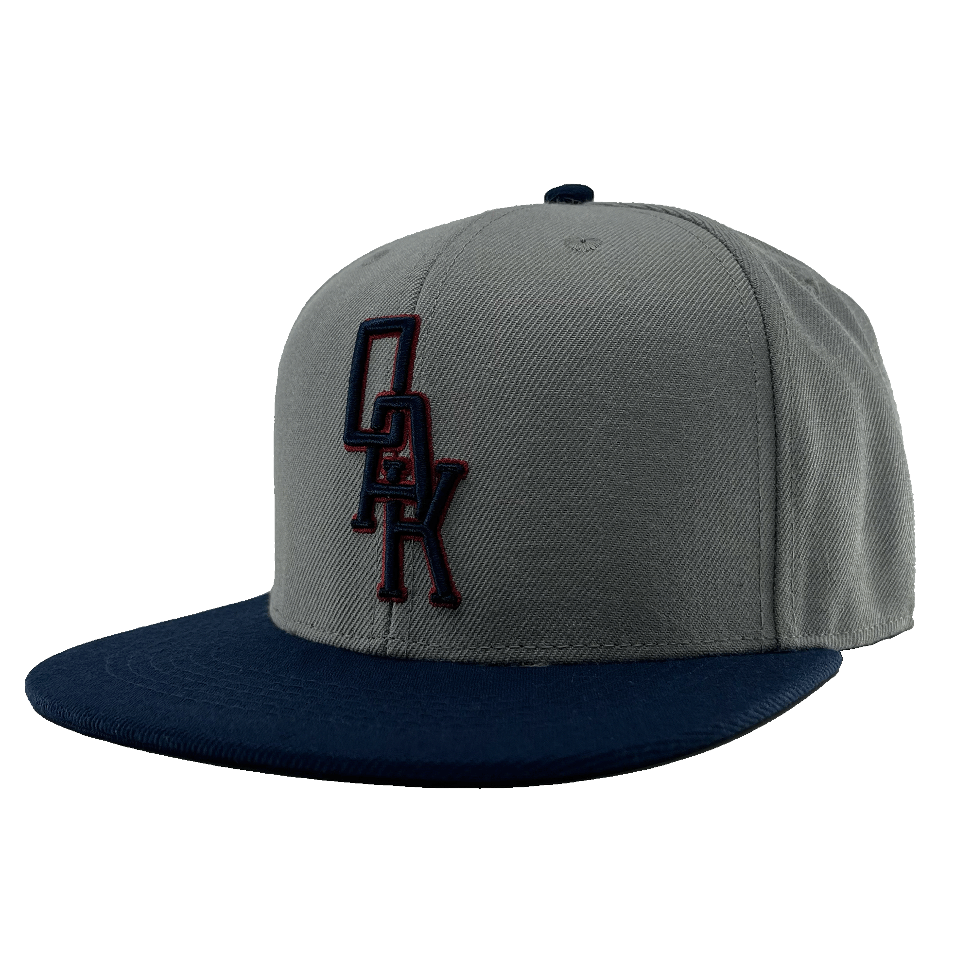 The OAK Monogram Snapback by Oaklandish features a gray crown with a flat, navy blue brim. An embroidered black OAK logo with a red outline adorns the front, and the top button matches in navy blue. Displayed from a front-angled perspective, this hat stylishly celebrates Oaklandish pride.