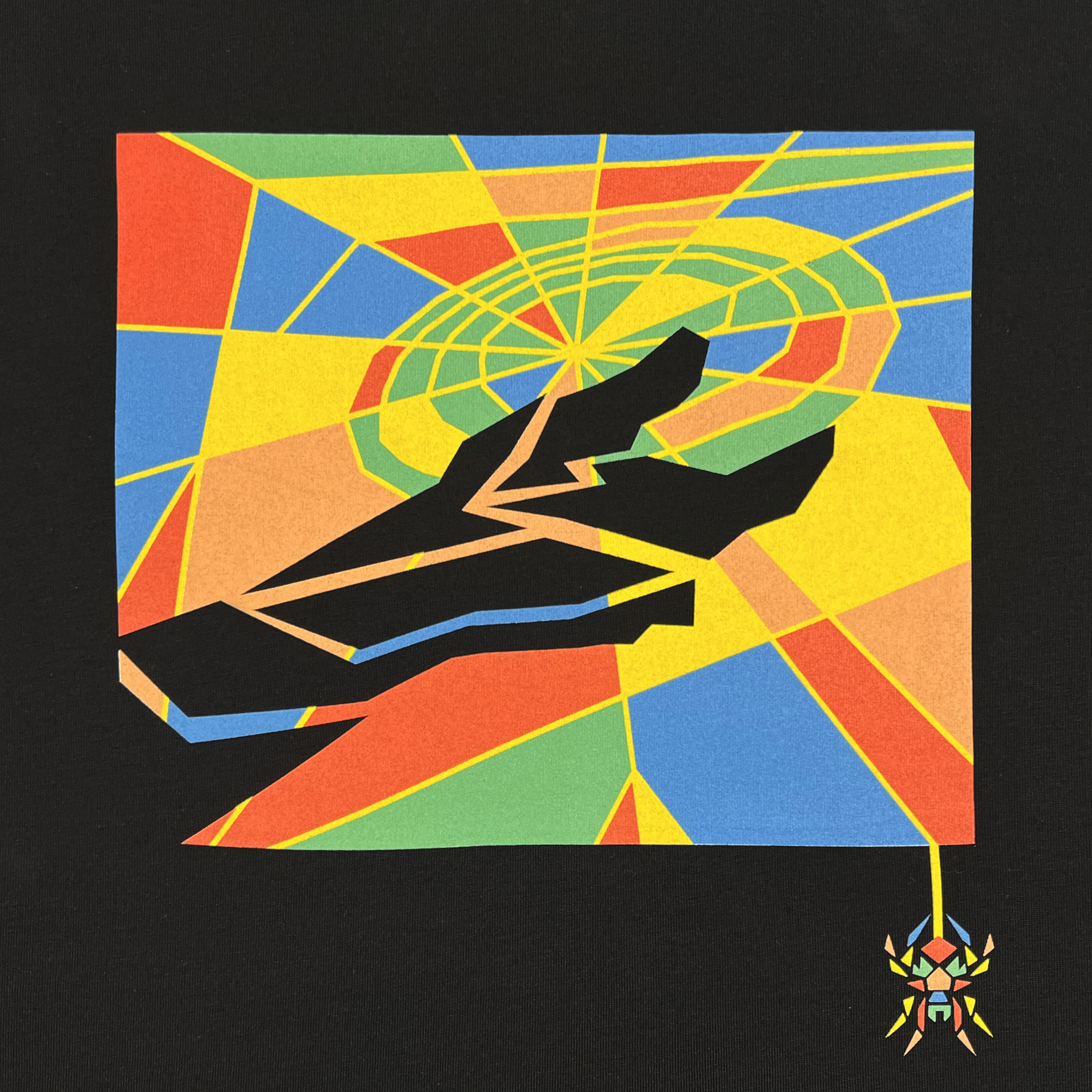 The Oakland Spiders Mosaic Tee by Supported Brands features a colorful abstract design on a black background, depicting jagged shapes in the foreground with vibrant geometric patterns in shades of yellow, blue, red, green, and orange in the background. In the corner hangs a small, multicolored spider connected by a thin thread reminiscent of an Oakland Spiders Ultimate Frisbee game.