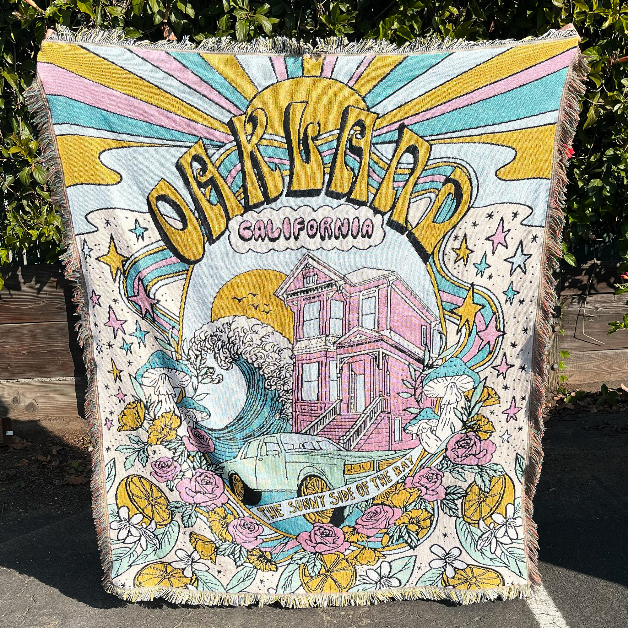 Front view of multi-color pastels Oakland dreaming blanket being held up upstairs.