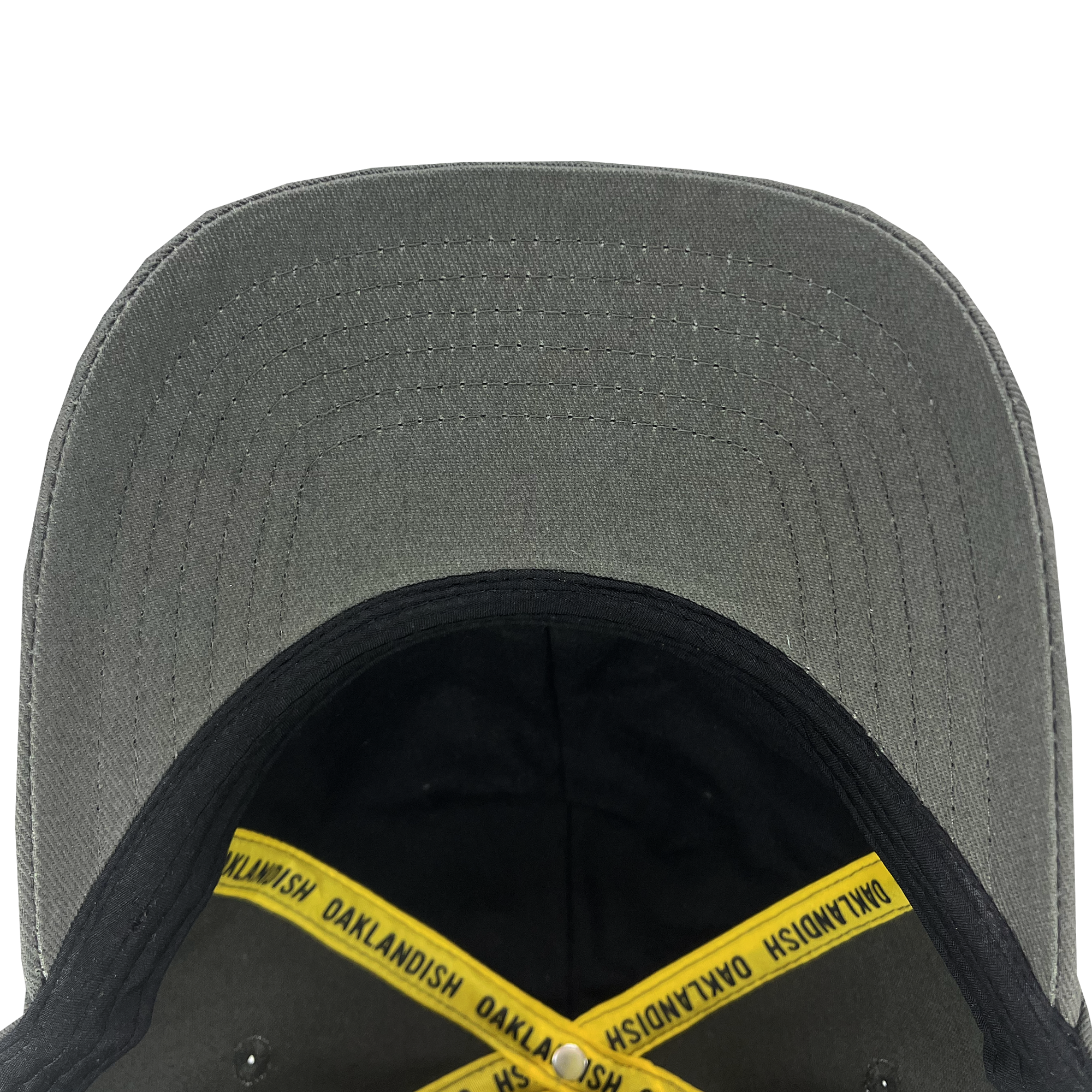 Inside crown of dark grey dad hat with yellow taping with Oaklandish wordmark on repeat and Oaklandish patch.