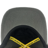 Inside crown of dark grey dad hat with yellow taping with Oaklandish wordmark on repeat and Oaklandish patch.
