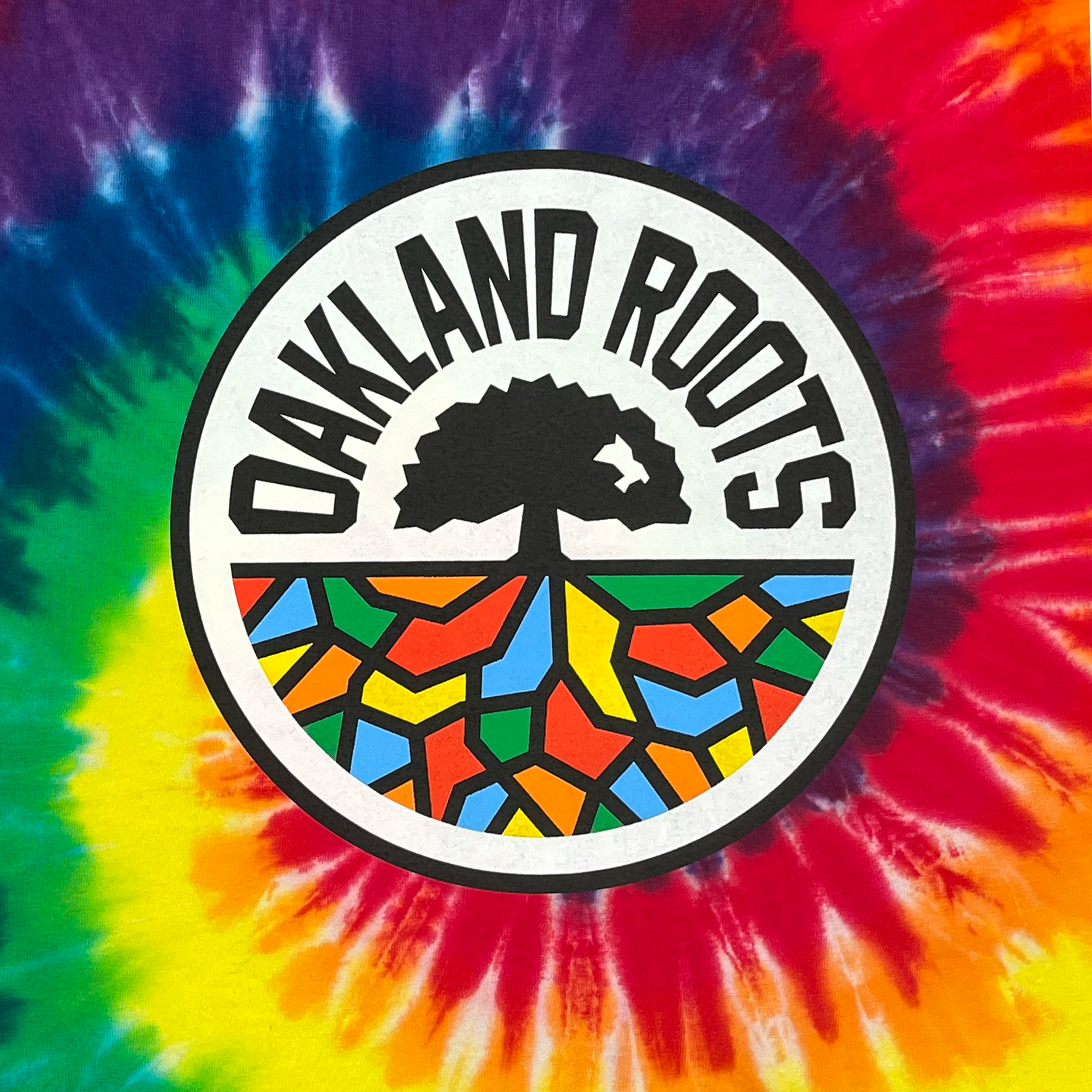 Detailed view of Rainbow Tie dye cotton t-shirt with Oakland Roots SC Crest.