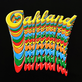 Detail close-up of Oakland wordmark in script on repeat in rainbow color on the front chest of a black t-shirt.