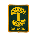 Forest green woven iron-on patch with gold Oaklandish tree logo and wordmark.