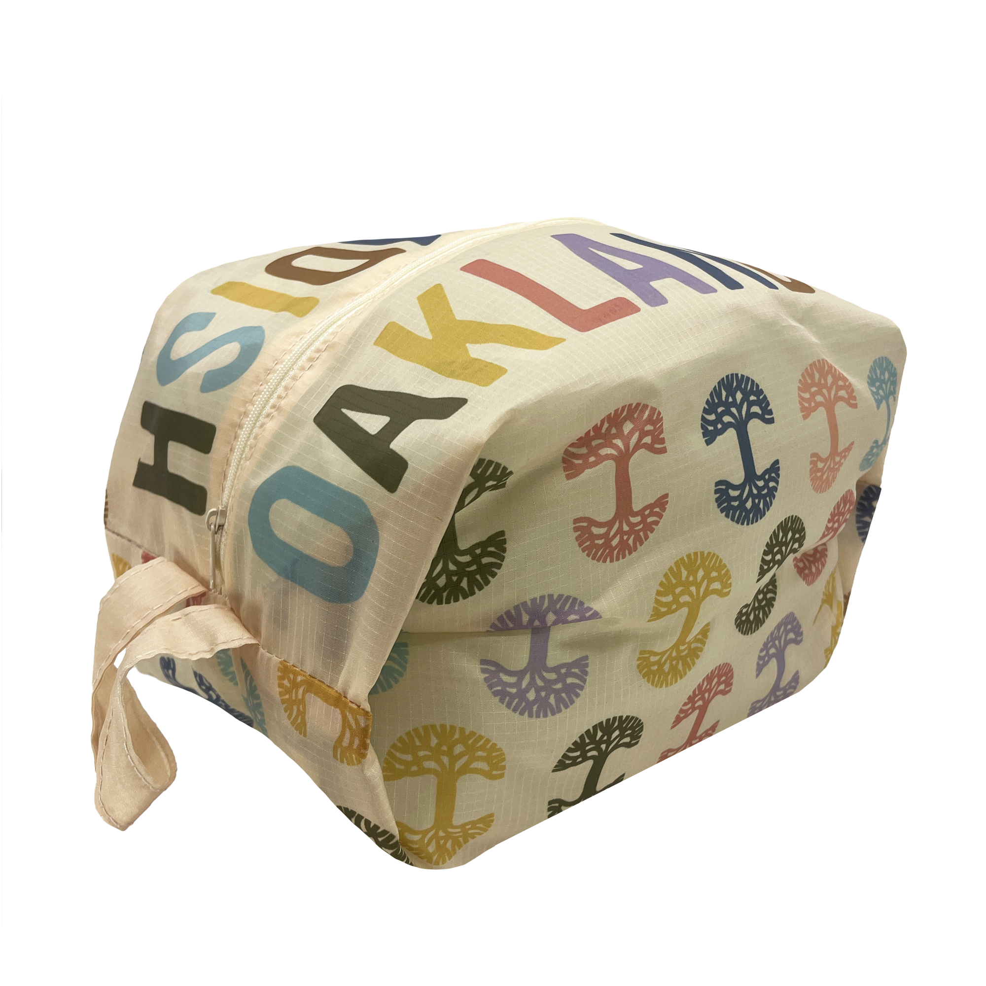 Above and side-angle view of a natural cream colored zippered toiletry dopp bag with multi-color Oaklandish tree logos on repeat and Oaklandish wordmarks on the top.