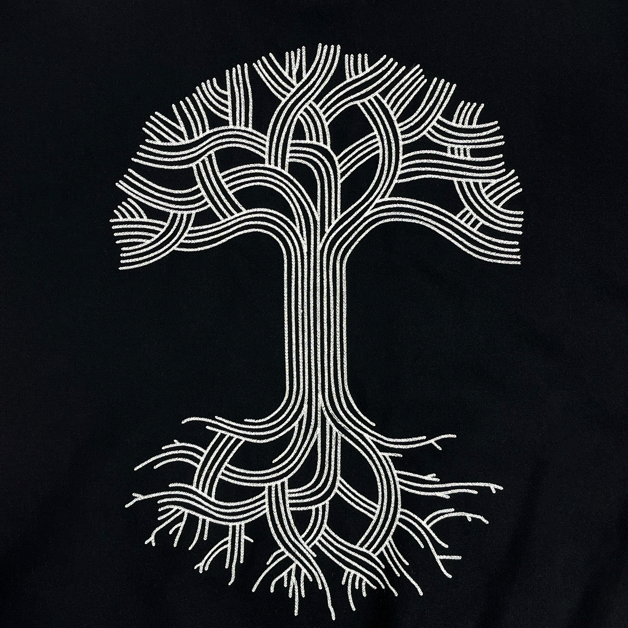 Large Oaklandish tree logo in the center back of a black and white varsity jacket.