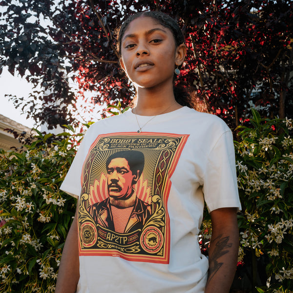Female model wearing Large illustrated graphic by Shepard Fairey, founder of Black Panthers on a natural color t-shirt .