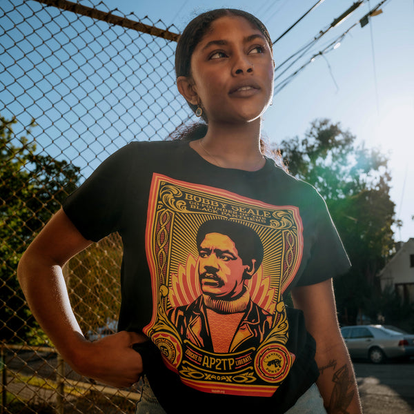Female model wearing women’s black t-shirt with a large illustrated graphic by Shepard Fairey, founder of the Black Panthers.