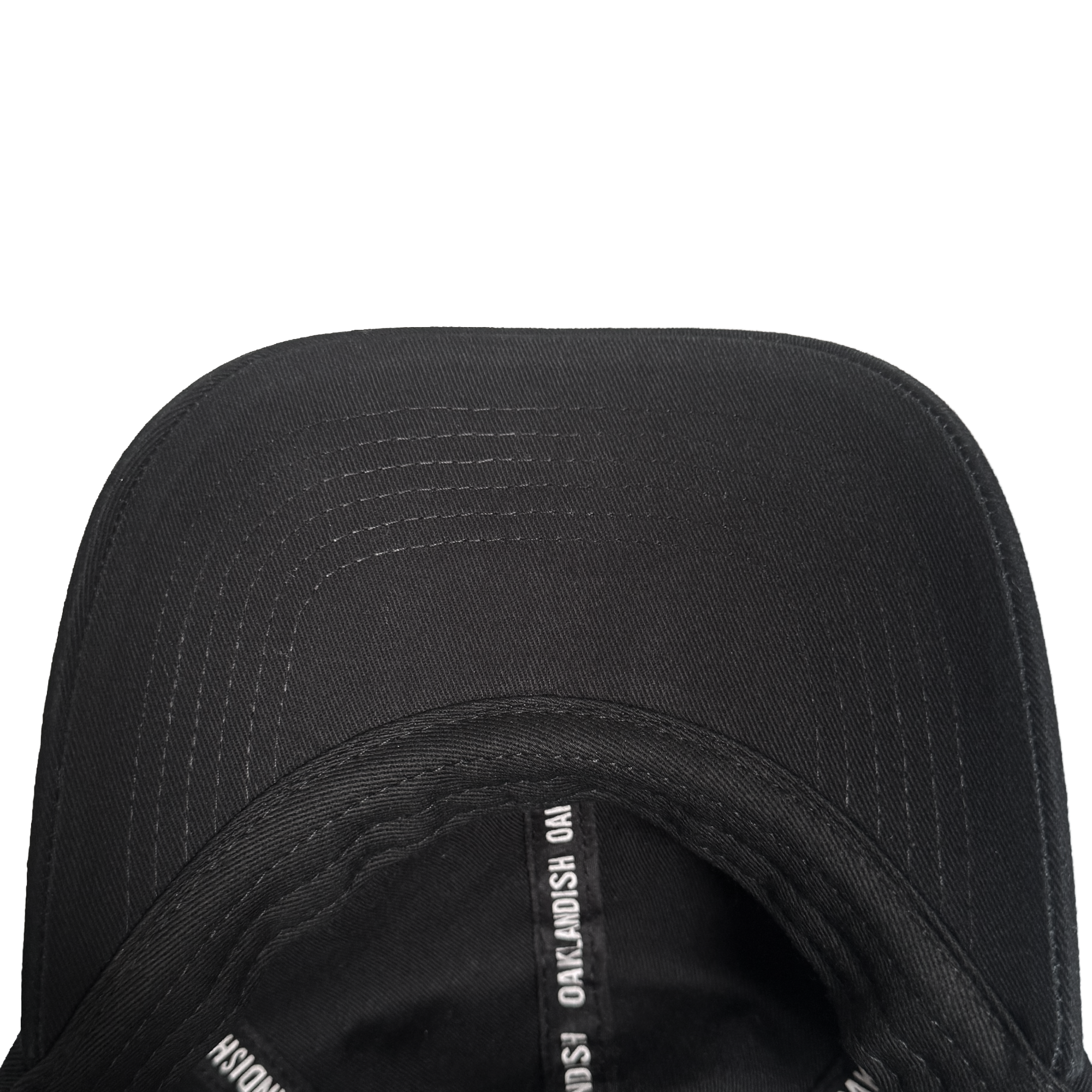 A close-up of a black Oakland Roots SC ORSC Dad Hat shows its curved brim with visible stitching arcs. The inner seam tape repeats white "NOAK MOSH" text on black. The background is plain white.