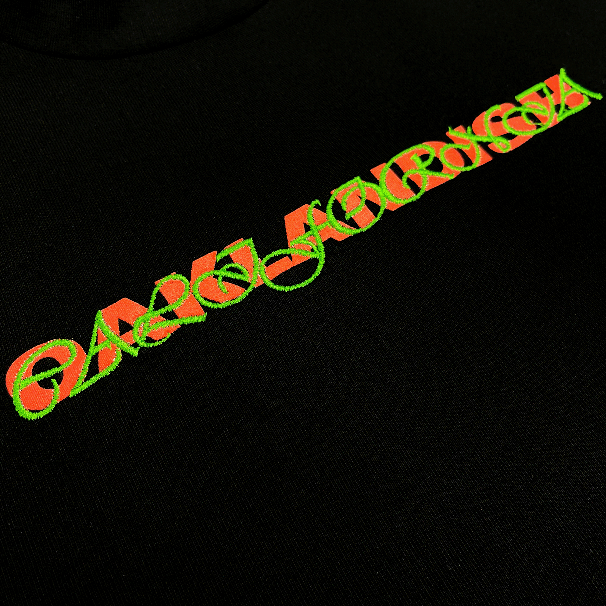 Detailed close-up on Oaklandish wordmark with green scripted Oaklandish wordmark on top on a black t-shirt.