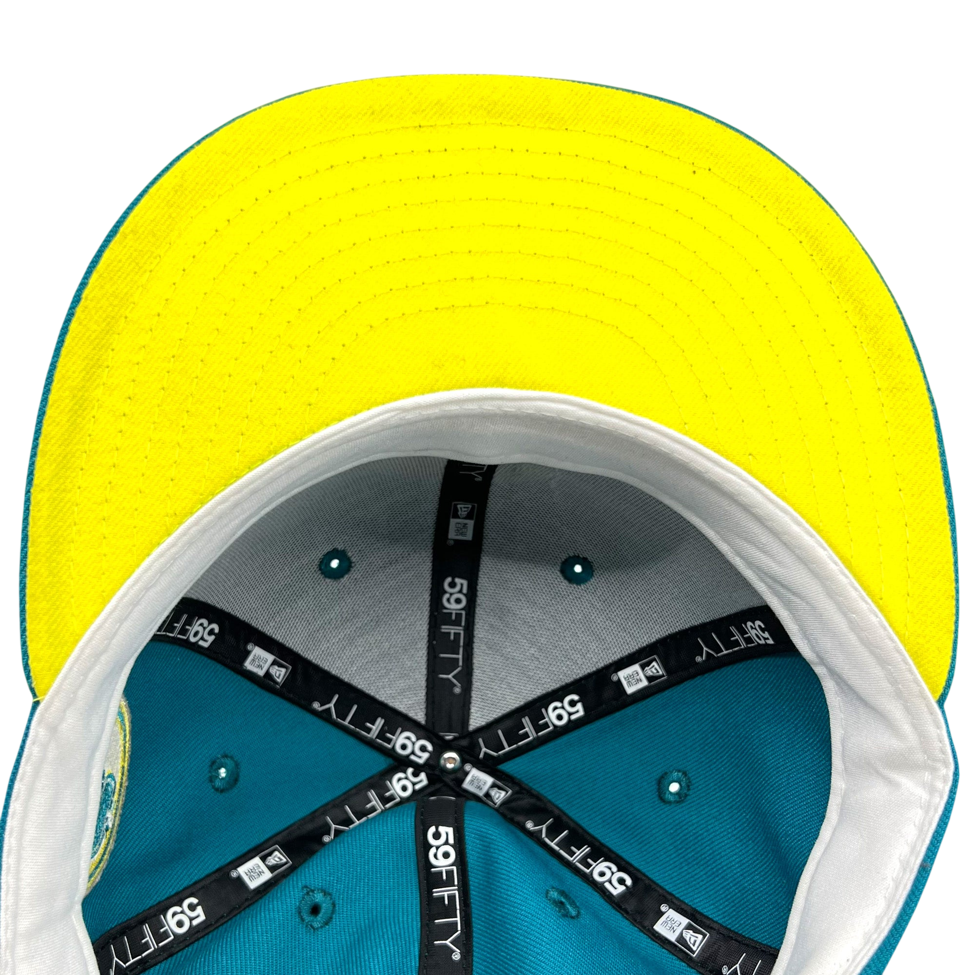 Here is the sentence rewritten with your product data: A top-down view of the New Era Oakland Oaks 59FIFTY Fitted Cap by Other showcases its yellow underside brim, teal crown, grey inner lining, white sweatband, and black taped seams featuring “59FIFTY” branding. The teal button at the center of the crown and the well-lit image further highlight the cap’s quality craftsmanship.