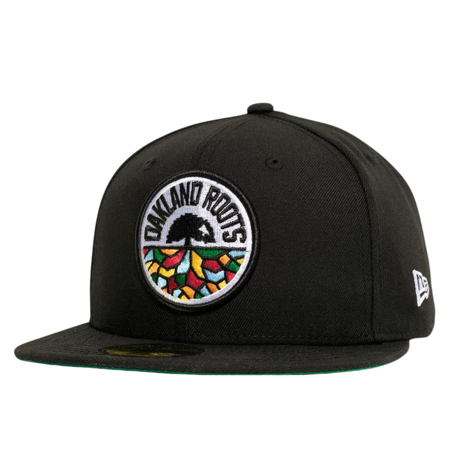 Introducing the New Era Oakland Roots SC 59FIFTY Fitted Cap: a stylish black cap featuring a colorful, circular embroidered logo on the front. This vibrant logo depicts a tree with an intricate root system and "Oakland Roots" text, symbolizing the Oakland Roots SC sports club. The cap includes a flat brim lined with green on the underside and is adorned with a small "New Era" logo on the side.
