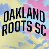Black Oakland Roots SC wordmark on a baby pink, yellow, and blue tie-dyed t-shirt.
