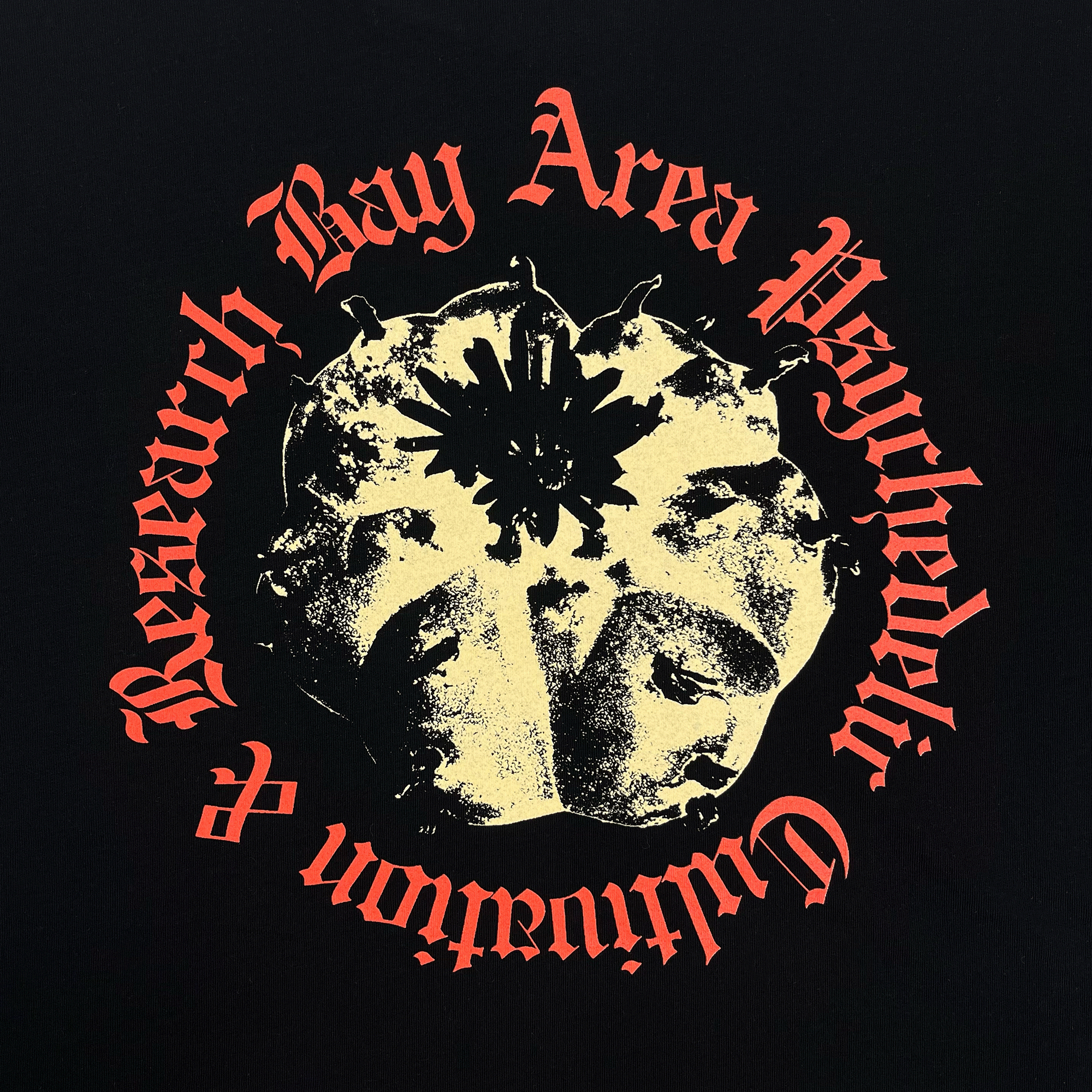 Close-up of the yellow and red mind's eye Peyo graphic and Bay Area Psychedelic Research wordmark on a black t-shirt..