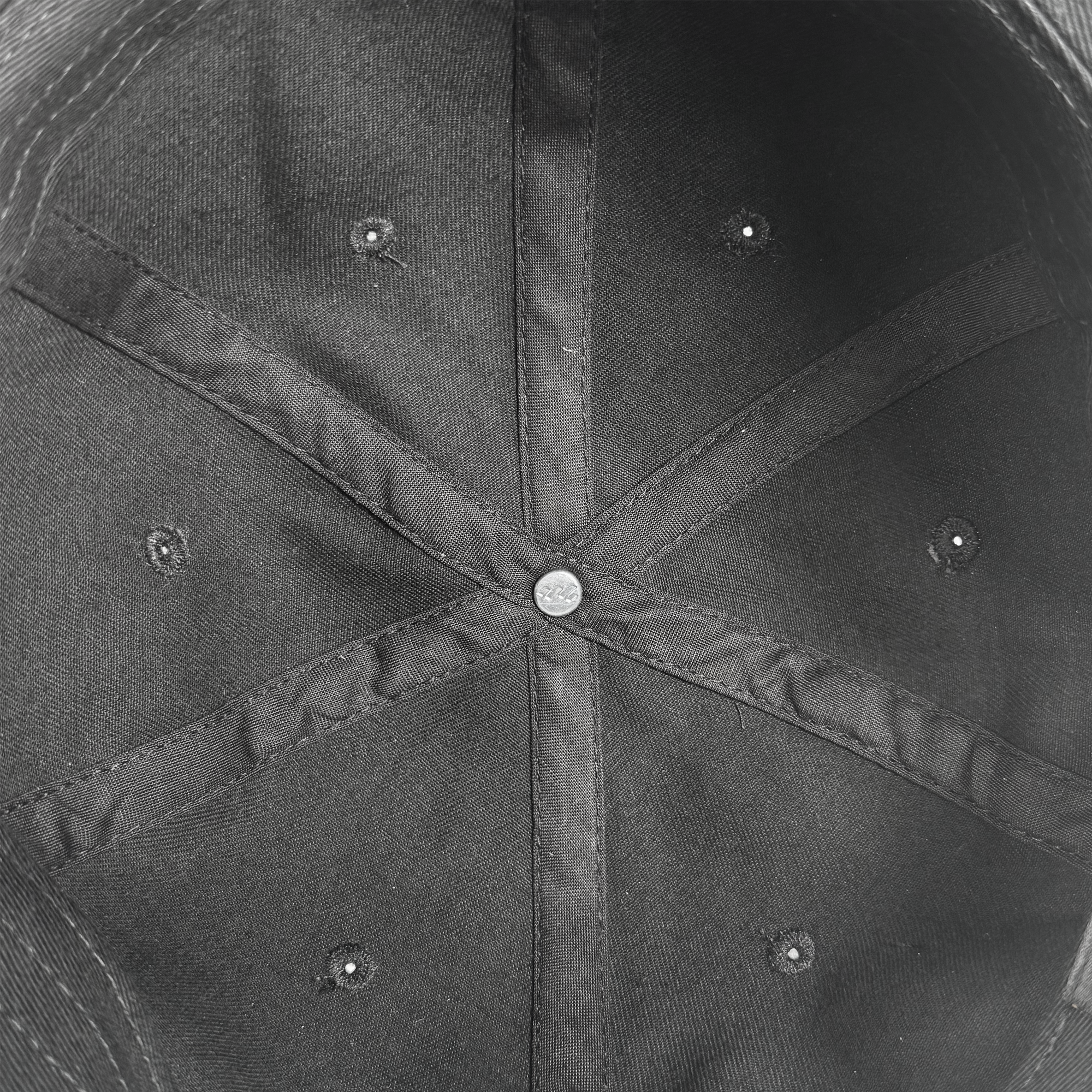 A close-up of the inside of the black Power of the People Dad Hat by Oaklandish, featuring stitched fabric panels and crossing seams—a subtle tribute to Black Panther legacy and Apparel of Social Consciousness.
