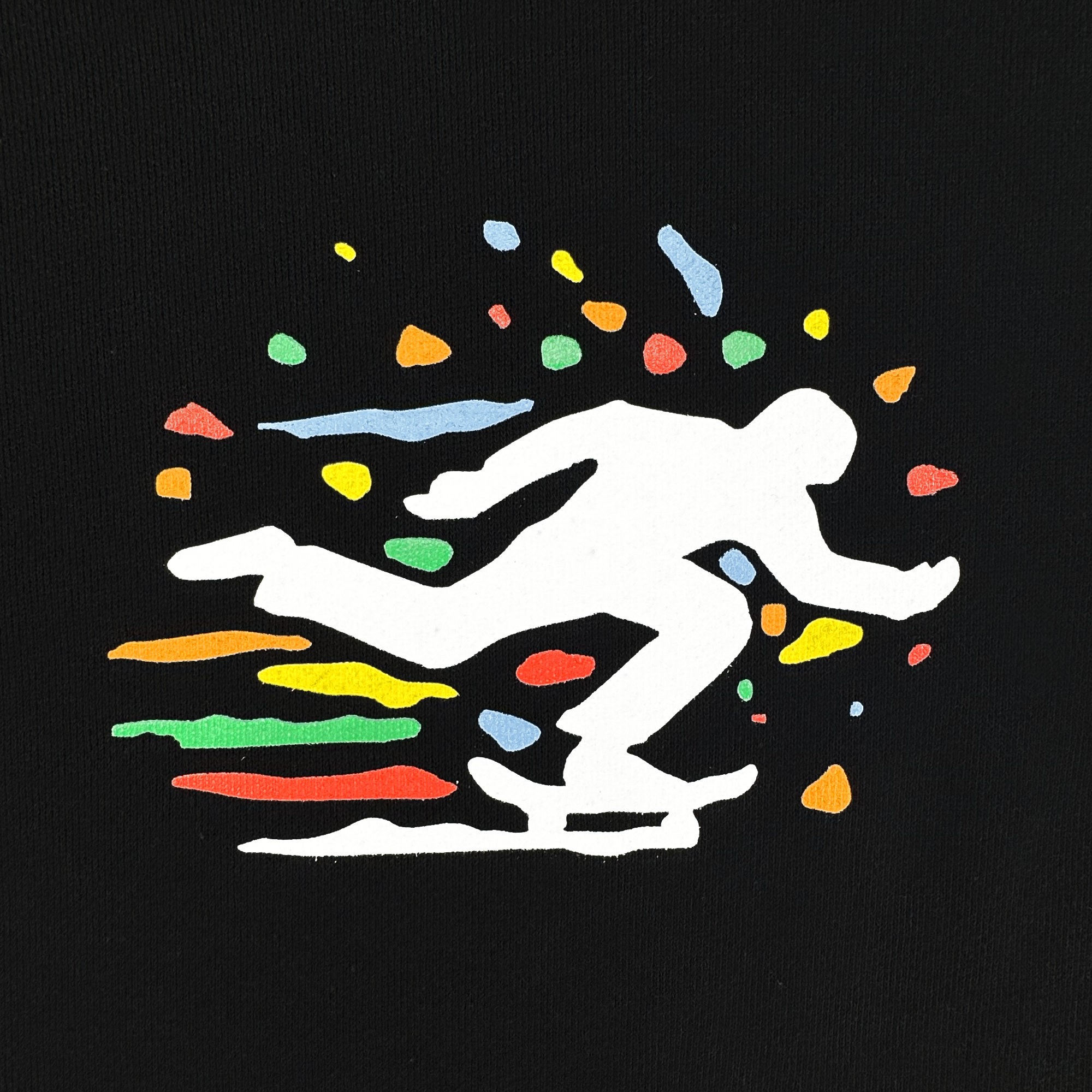 The Oakland Roots SC X Break Free Tee by Oakland Roots SC features a white skateboarder silhouette inspired by Oakland culture, surrounded by vibrant red, yellow, green, blue, and orange confetti on a solid black background.