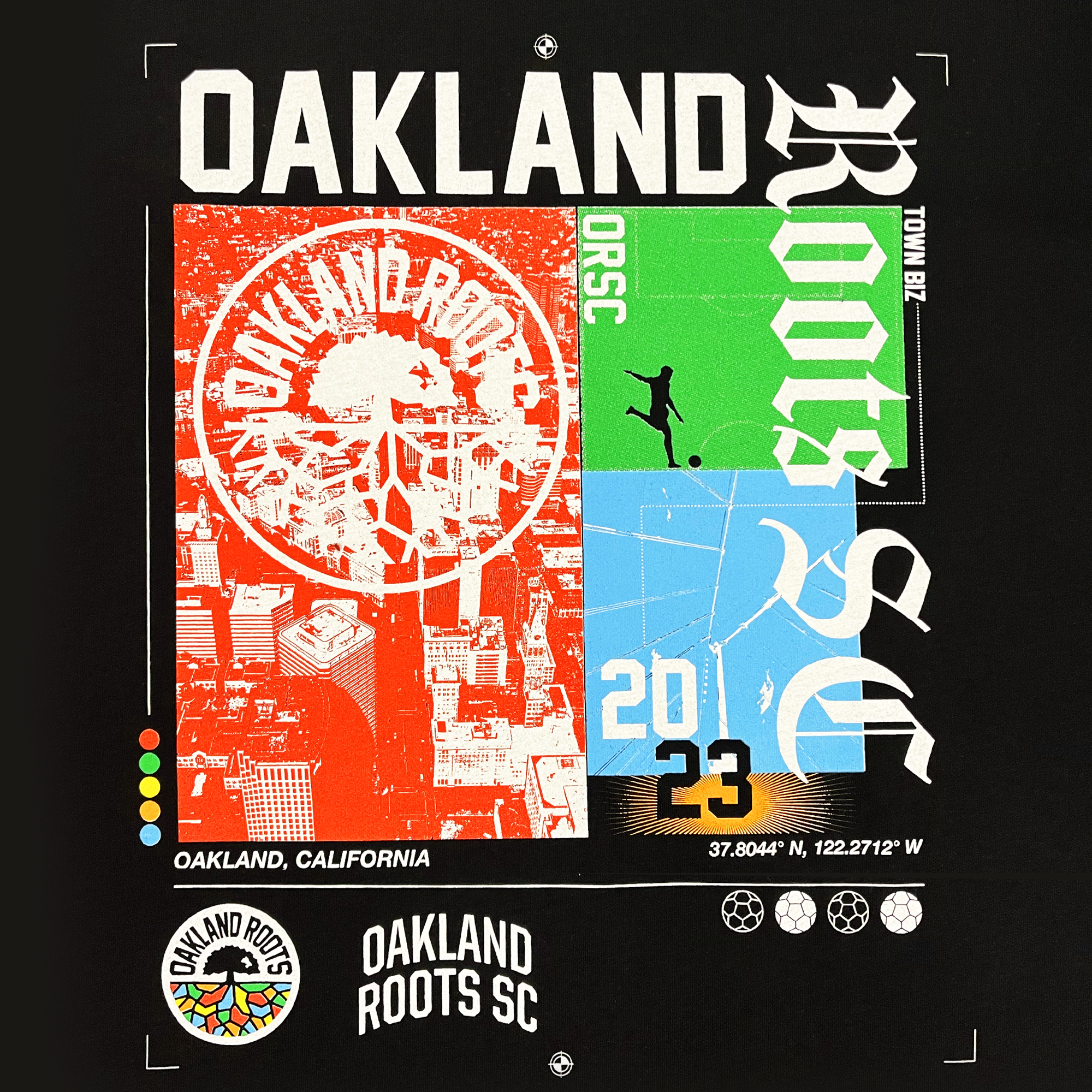 Close-up of large multi-color Futboltown Oakland Roots SC graphic, wordmarks, and logos on the back of a black t-shirt.