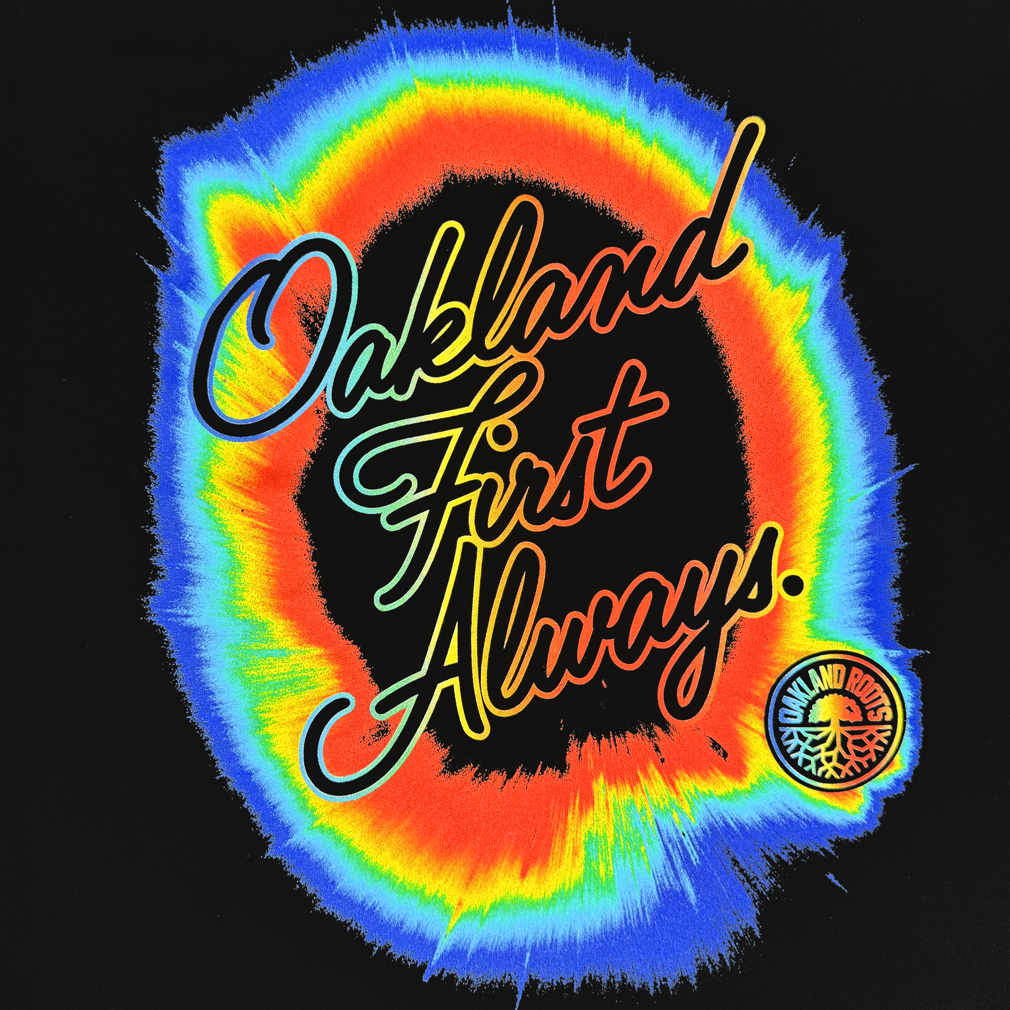 The OFA Rad Roots Tee by Oakland Roots SC features "Oakland First Always." in bright orange script over a rainbow burst on black, with the club’s round tree logo at the lower right—perfectly capturing the Oaklandish spirit.
