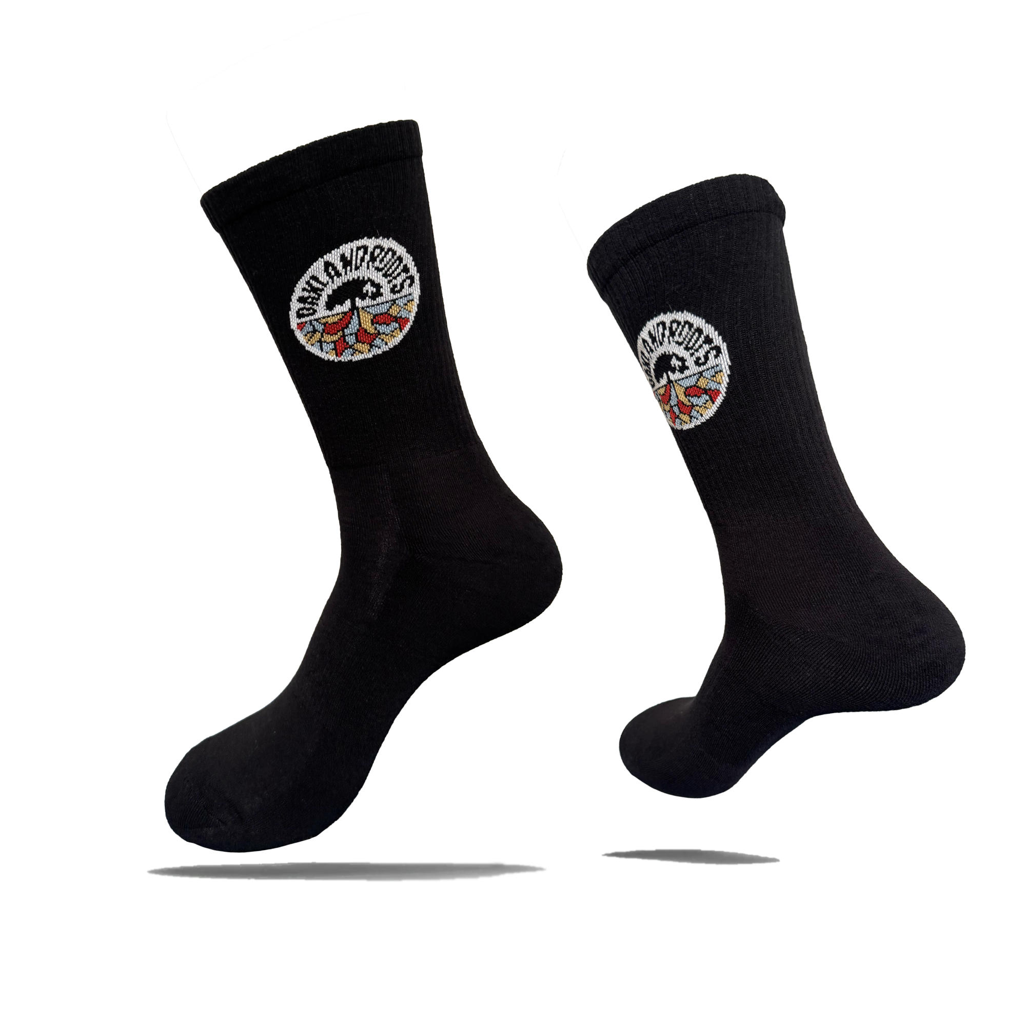Two black cotton crew Roots SC Socks by Oakland Roots SC are shown against a white background. Each adult-sized sock features a round “NOMAD NOMADS” patch with colorful wings near the top and appears to float with shadows below.