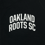 Close up of white OAKLAND ROOTS SC wordmark on the chest of black hoodie.