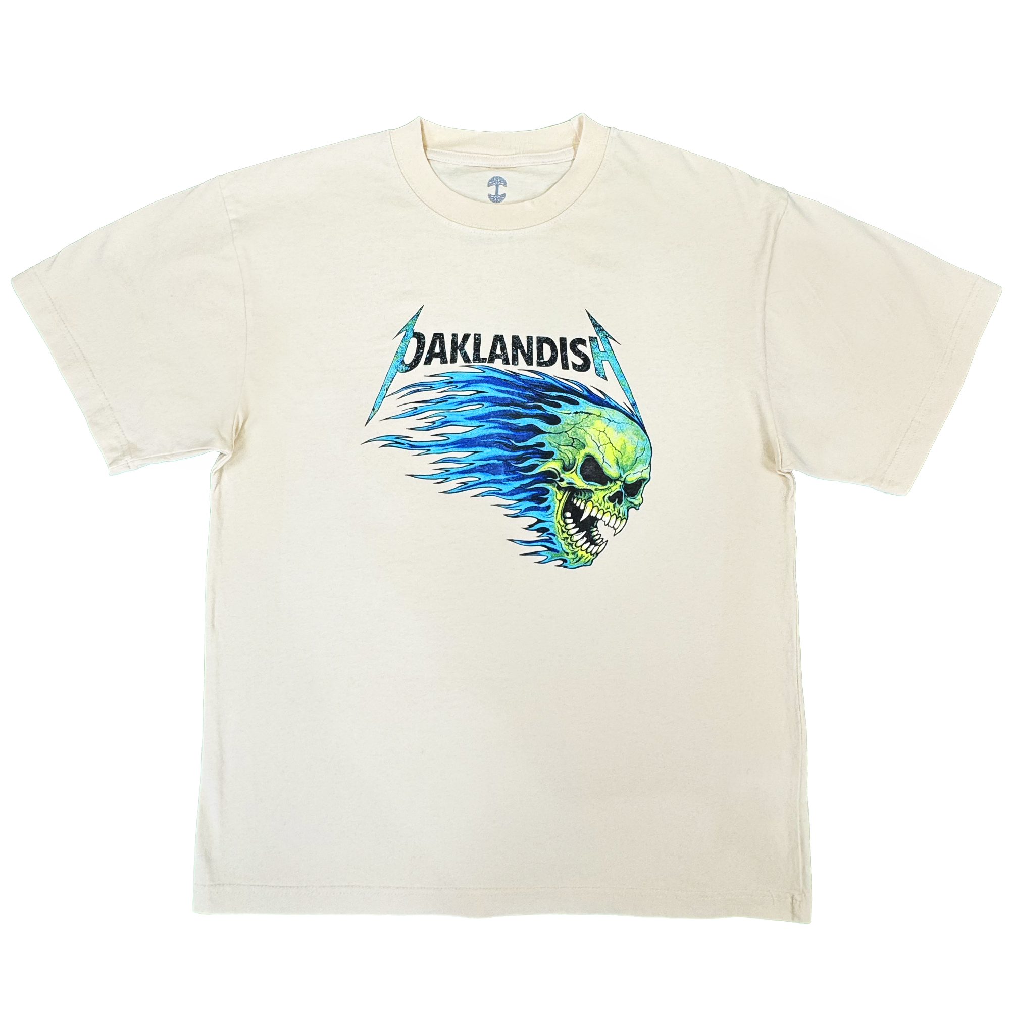 Introducing the Sandman Tee by Oaklandish: a men’s cotton t-shirt in cream, featuring “OAKLANDISH” in black, stylized lettering above a bold green flaming skull graphic with blue flames extending behind it, all centered on the chest. This classic fit tee comes with short sleeves and a simple crew neckline.