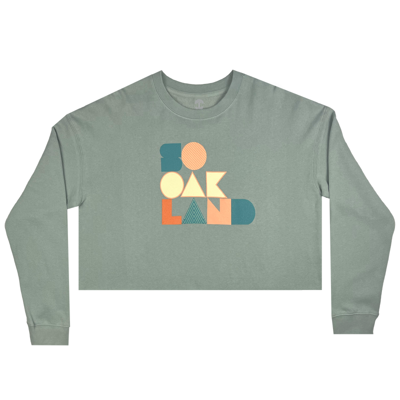 Cropped crewneck sage green sweatshirt with a full-color SOOAKLAND graphic wordmark on the front chest.