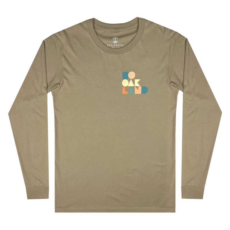 Front view of sand-colored long-sleeved t-shirt with full-color SOOAKLAND graphic wordmark on left wear side chest 