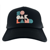 Front view of a black trucker cap with full-color SoOakland wordmark in the crown.