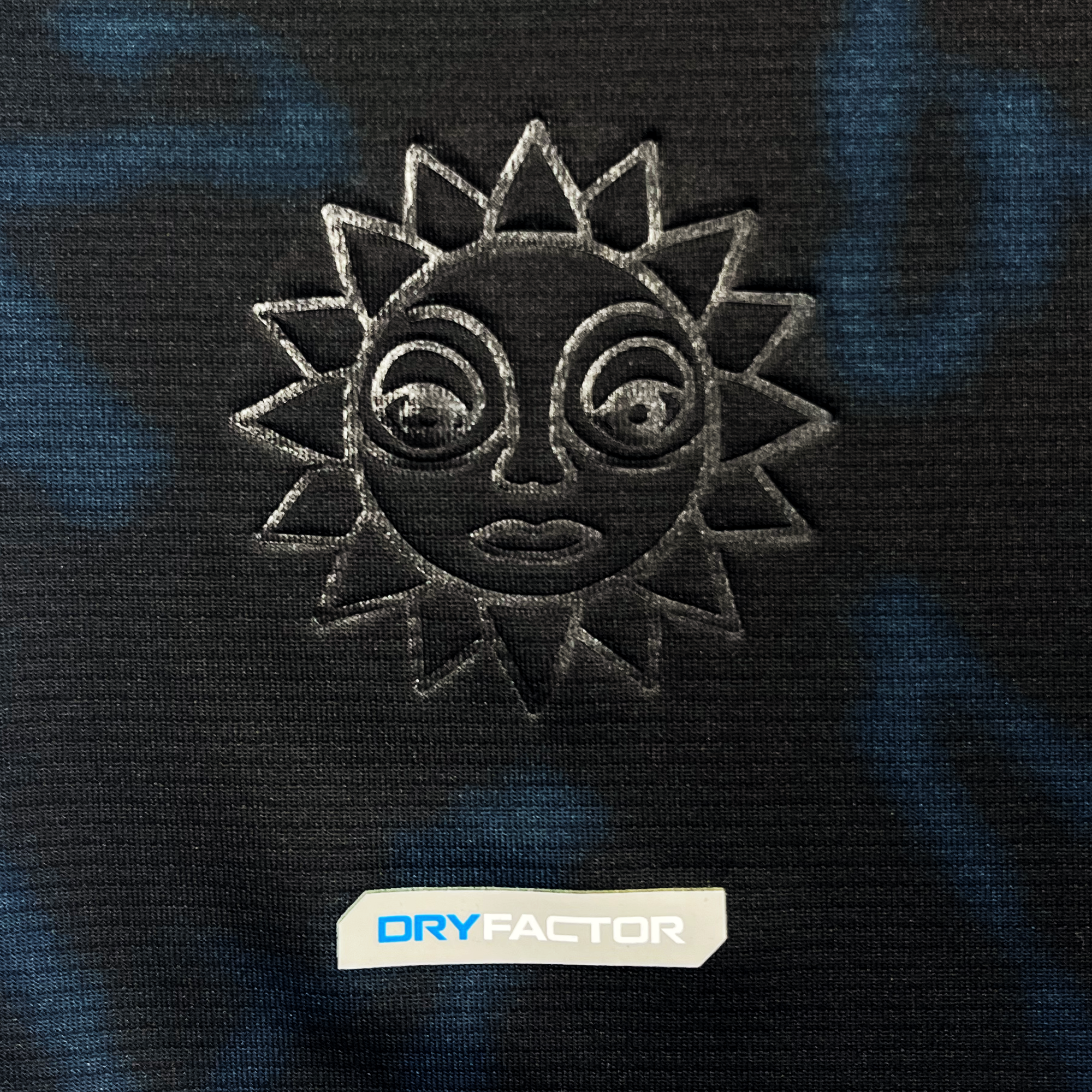 Detailed view of embossed Oakland Soul sun logo on black Oakland Soul jersey.
