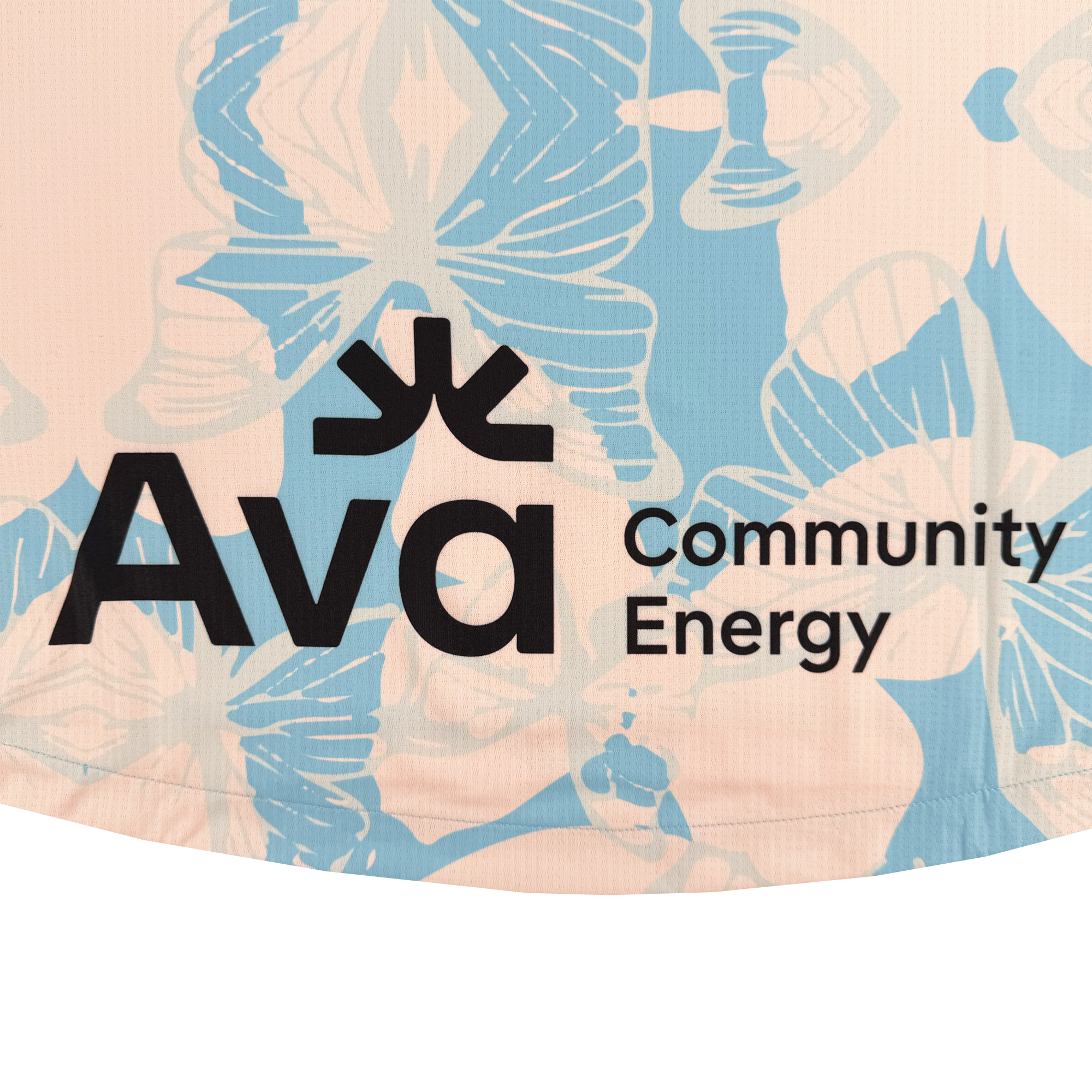 Close-up of fabric from the Custom Unisex Butterfly Effect Kit by Oakland Soul, showing a blue and white butterfly pattern on light pink. Bold black "Ava Community Energy" text features three upward lines above the "v," in an Oakland-inspired design.
