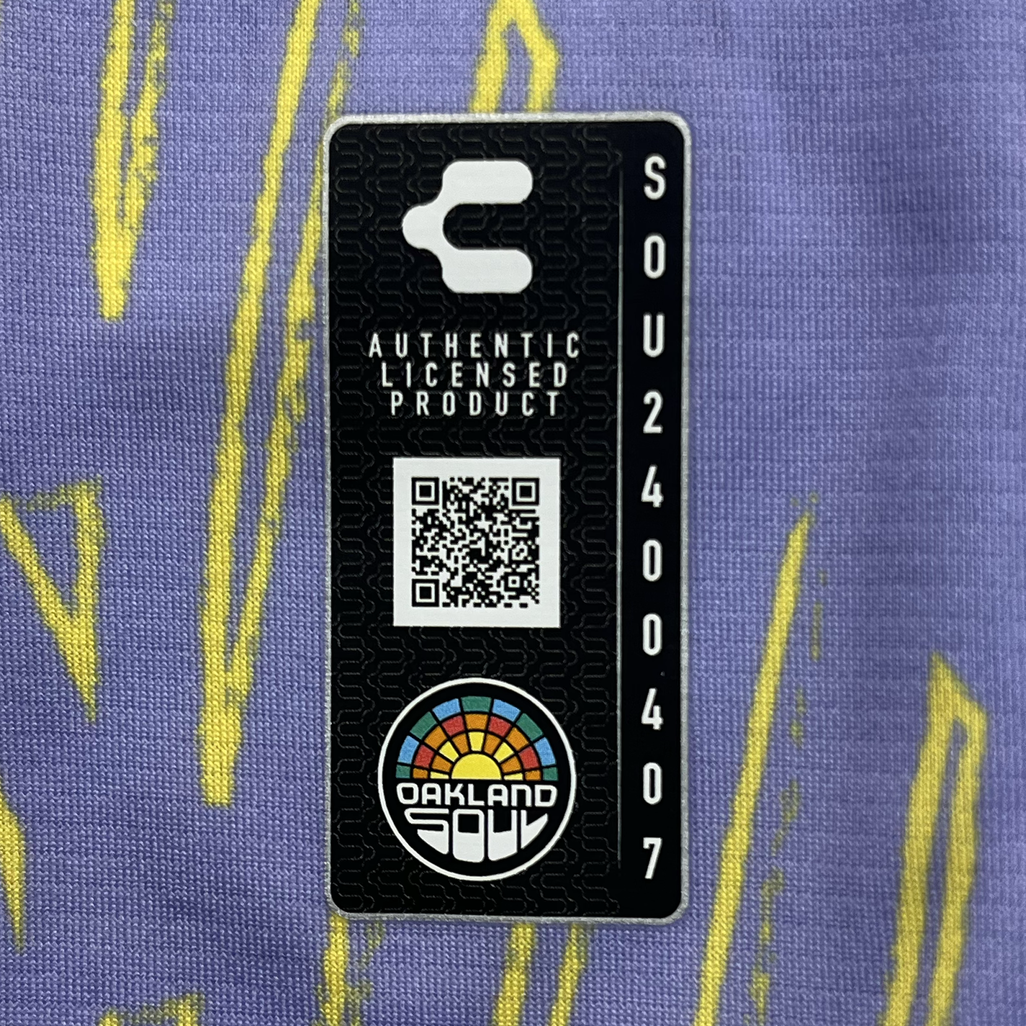 Charly authentic license tag and QR code detailed view of lavender color Oakland Soul x Charly soccer jersey.