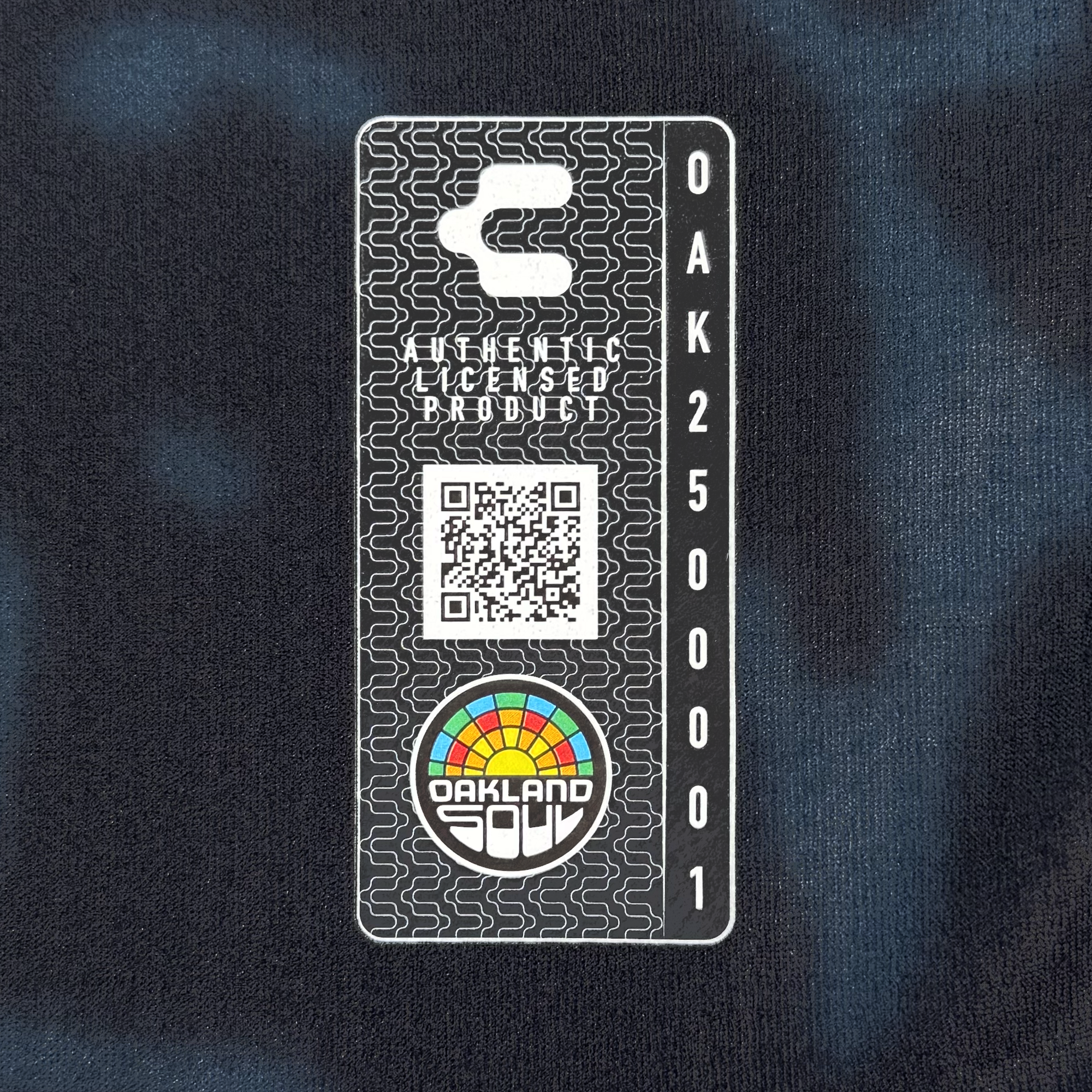 A rectangular label on black fabric for the Custom The Soul Bloom Kit by Oakland Soul reads “OFFICIALLY LICENSED PRODUCT” above a QR code, with “OAKLAND” and “250001” vertically, plus a rainbow semicircle logo and "OAKLAND SOUL." at the bottom.