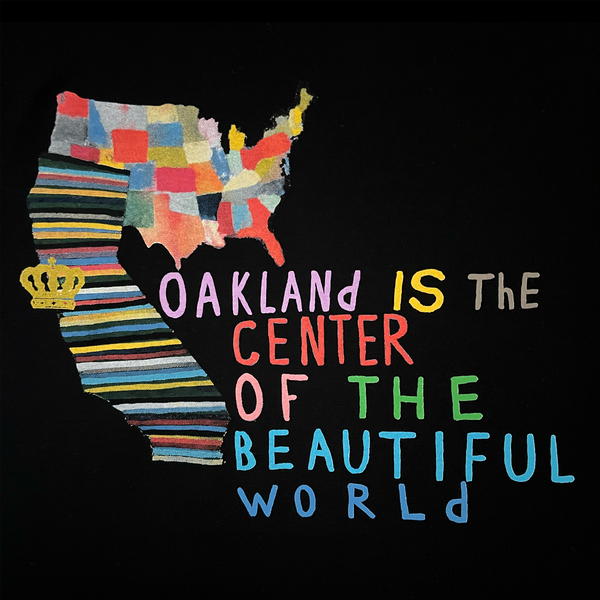 Close-up of Oakland Is the Center of World mural art by contemporary artist Squeak Carnwath on a black cotton t-shirt.
