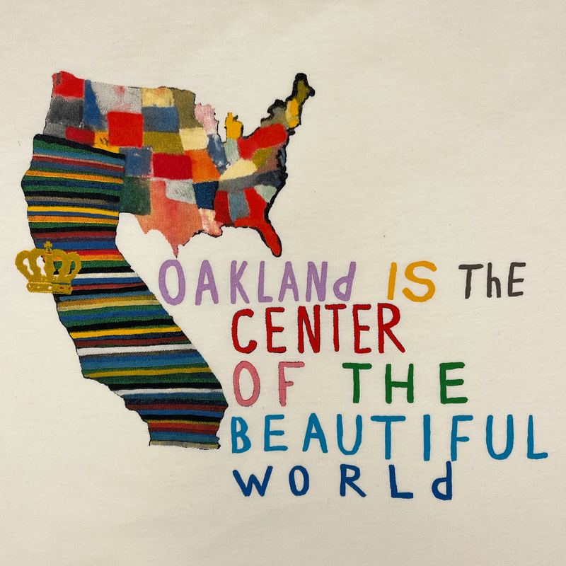 Close-up of Oakland Is the Center of World mural art by contemporary artist Squeak Carnwath on a natural cotton t-shirt.