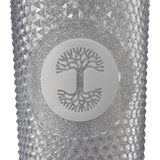 A detailed close-up of the Oaklandish tree logo is sparkly silver on front of a silver-studded bling travel tumbler. 