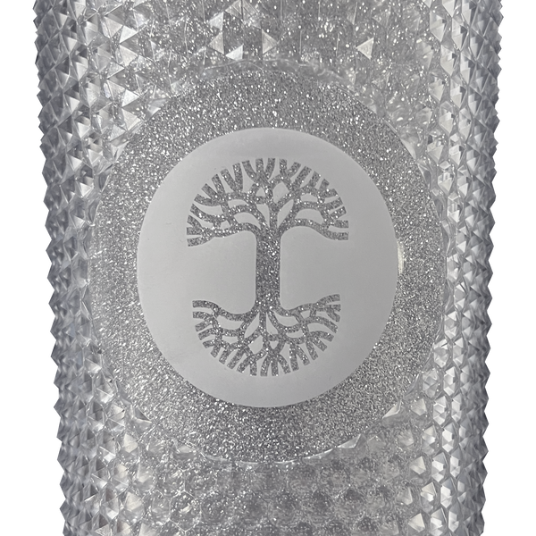 A detailed close-up of the Oaklandish tree logo is sparkly silver on front of a silver-studded bling travel tumbler. 