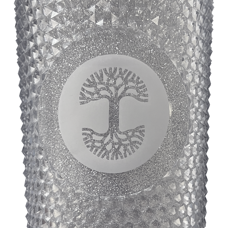 A detailed close-up of the Oaklandish tree logo is sparkly silver on front of a silver-studded bling travel tumbler. 
