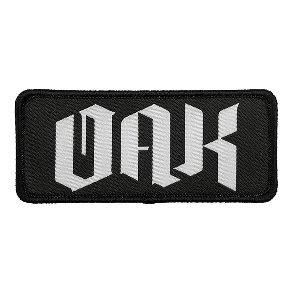 Woven black iron-on patch with white OAK wordmark in drip.