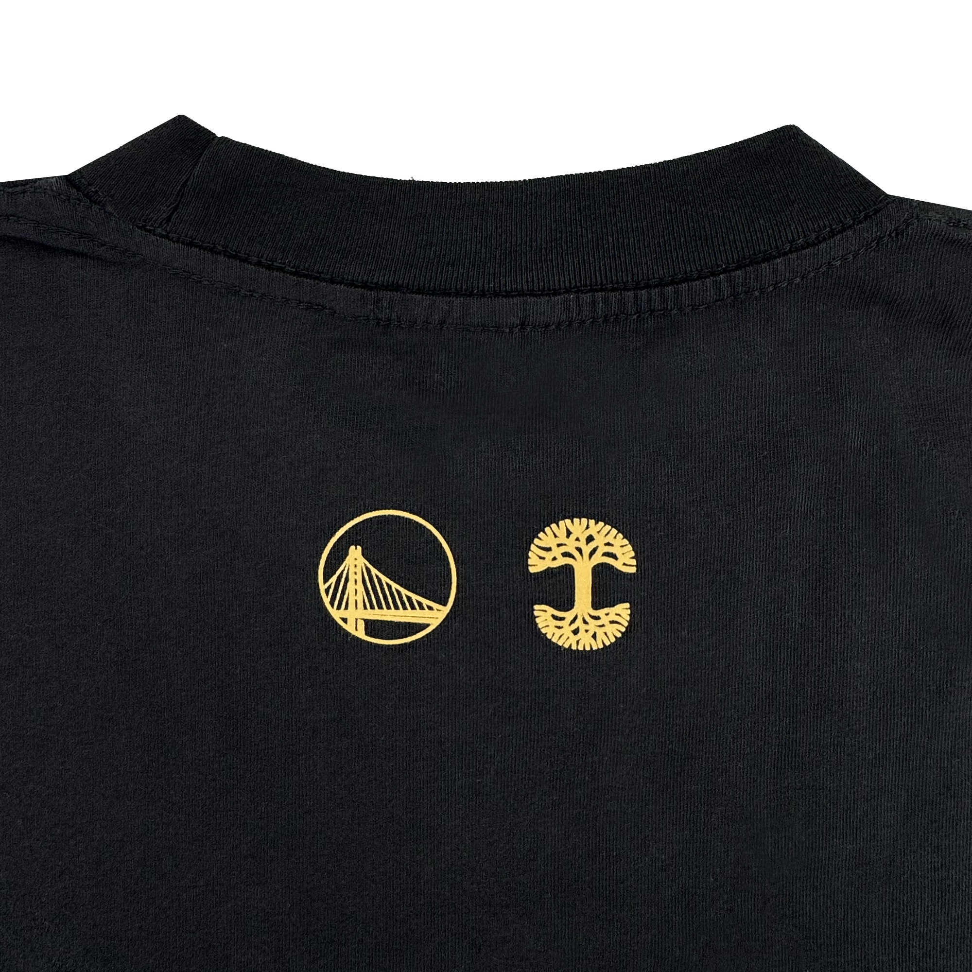 A close-up of the Town Doodle Tee by GSW shows its black back neckline with two small yellow embroidered logos—a circular Oaklandish-style bridge on the left and a spreading tree on the right—set against a plain light gray background.