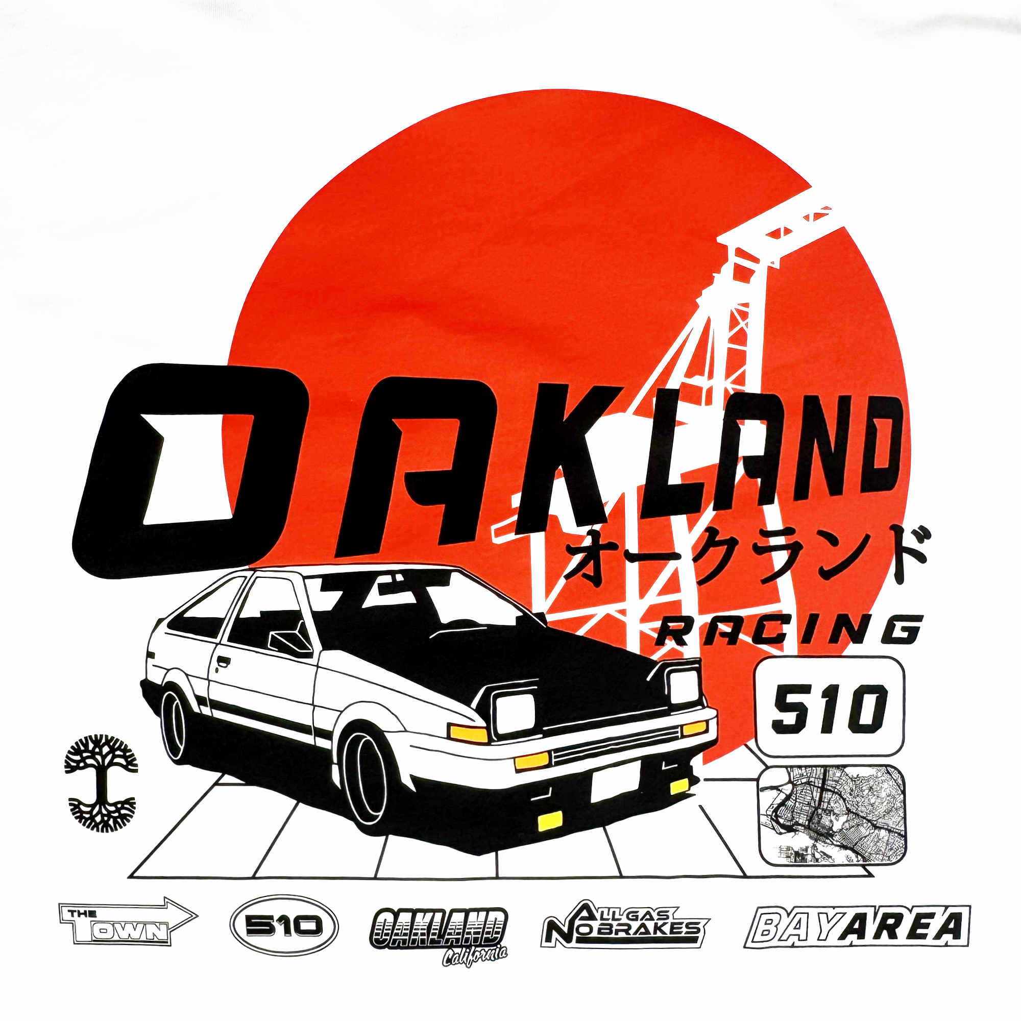 The Tuner LS Tee by Oaklandish features a stylized design of a white sports car with a red sun and black crane, text "OAKLAND RACING" in English and Japanese, and logos "The Town," "510," and "Bay Area." Made from 100% cotton for a classic fit.