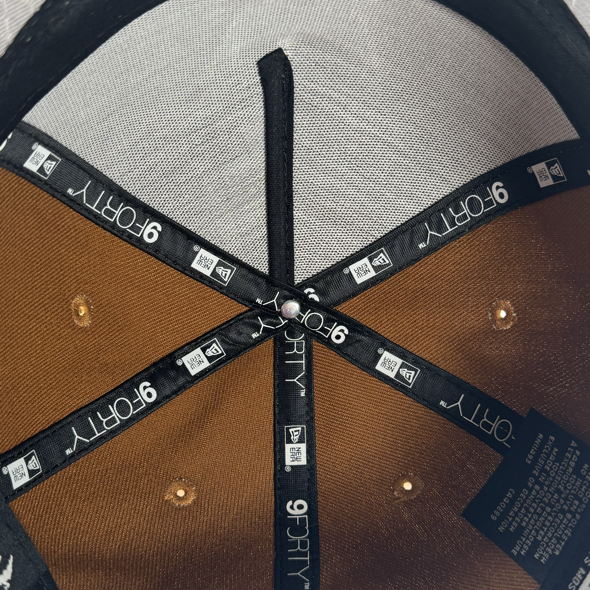 Close-up of the GSV Logo 9FORTY AF Snapback by GSV, highlighting brown and black fabric panels, stitched "9FORTY" and GSV logos, a silver rivet, and care labels—an authentic adjustable snapback for Golden State Valkyries fans.