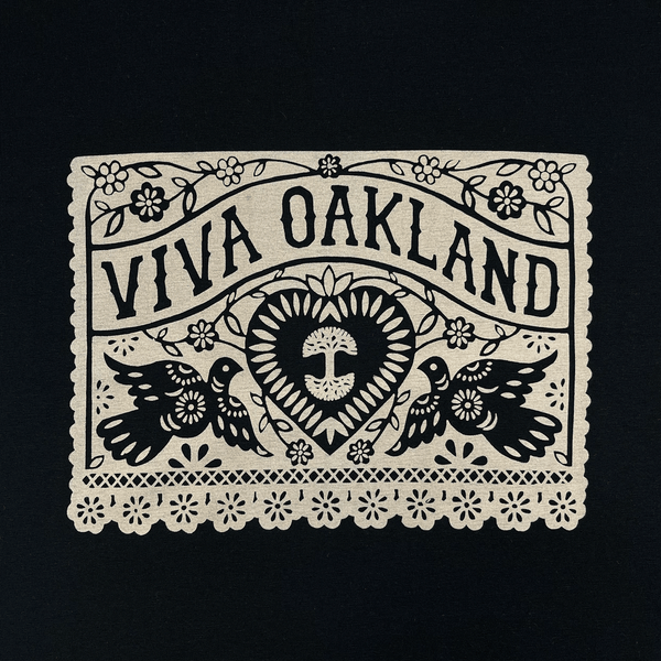 Close-up of intricate lace gold Viva Oakland graphic on the front chest of a black t-shirt.