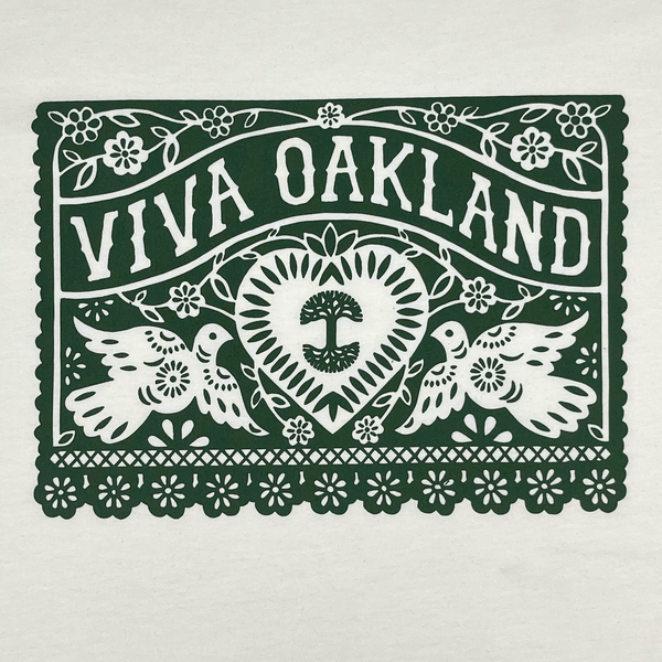 Close-up of intricate lace green Viva Oakland graphic on the front chest of a natural cotton colored t-shirt.