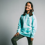 Girl wearing a mint green youth hoodie with a purple Oaklandish wordmark on the chest.