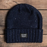 White flecked navy cuffed beanie with Oaklandish tag on the front on wood deck.