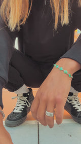 Male dancing outside in downtown Oakland wearing a black Oaklandish hoodie and jogger set.