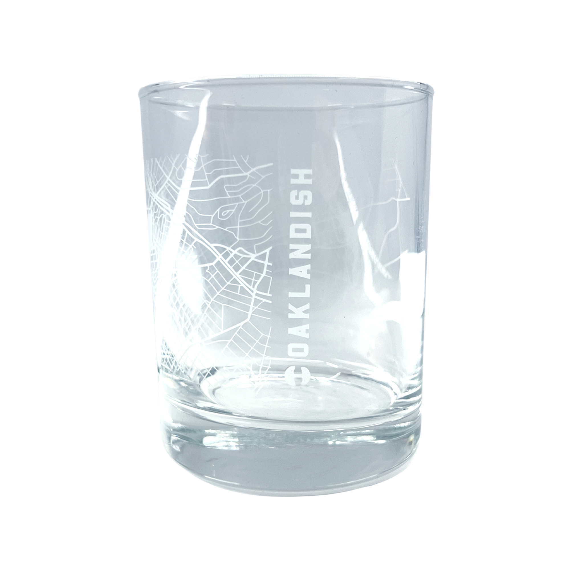 The reverse side of a clear glass whisky tumbler with an etched aerial map of Oakland & Oaklandish wordmark.