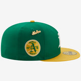 Side view of green cap with 1973 World Series patch and yellow cursive New Era logo.