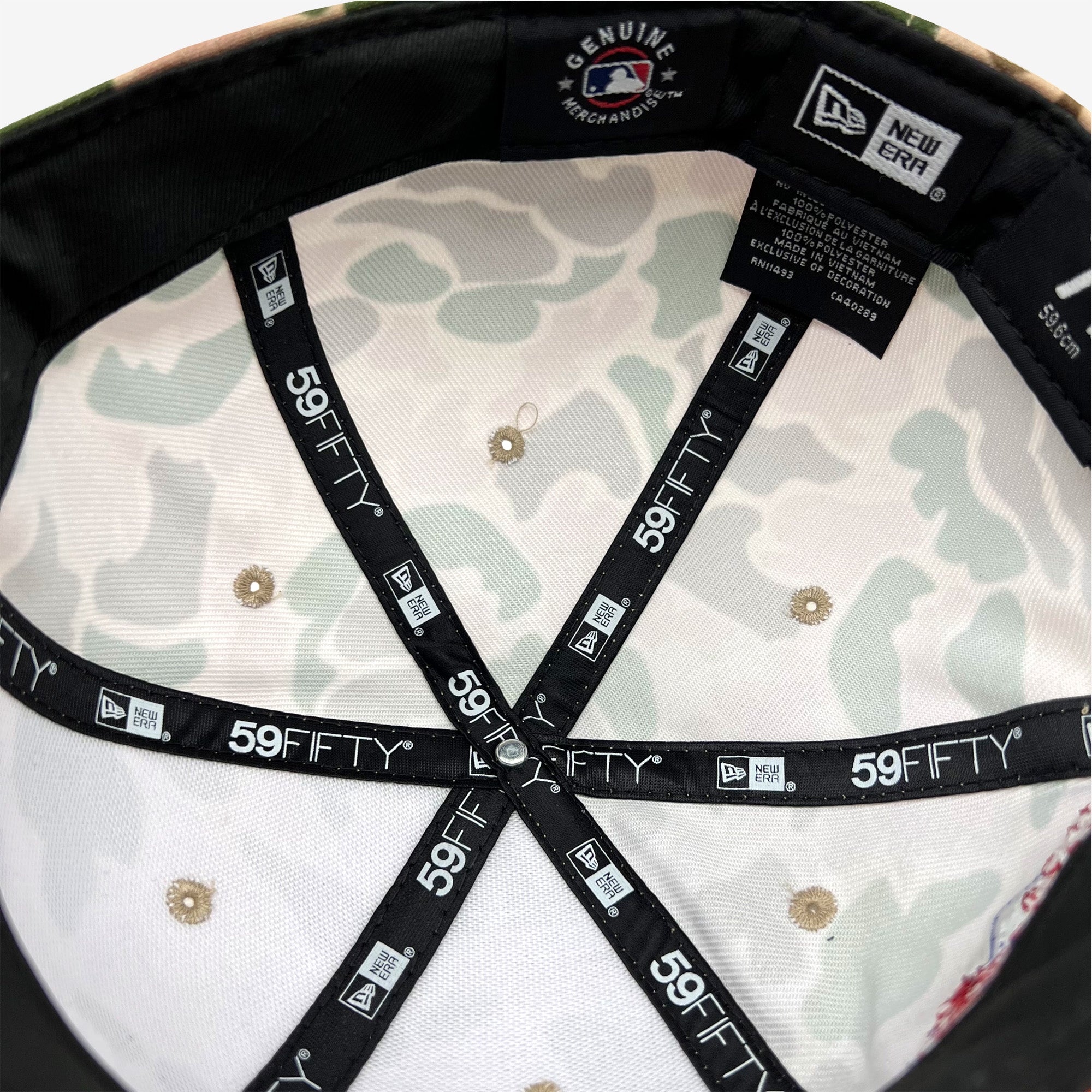 Interior view of a New Era Oakland A's 59FIFTY fitted cap by Retail Vendors. The cap features a white fabric with a light green Duck Camo pattern inside. Black bands with white stitching criss-cross the interior, each labeled with "59FIFTY". The "Genuine Merchandise" and "New Era" logos are visible, along with care labels.